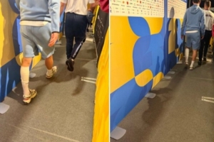赖斯赛后步履蹒跚通过混合采访区，左小腿绑有绷带